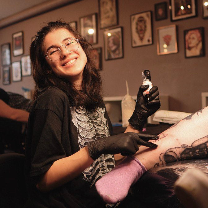 Tattoo artist Anastasia (an_anast_tattoo) working on a client in a tattoo parlor called Ink & Intuition in Amsterdam.